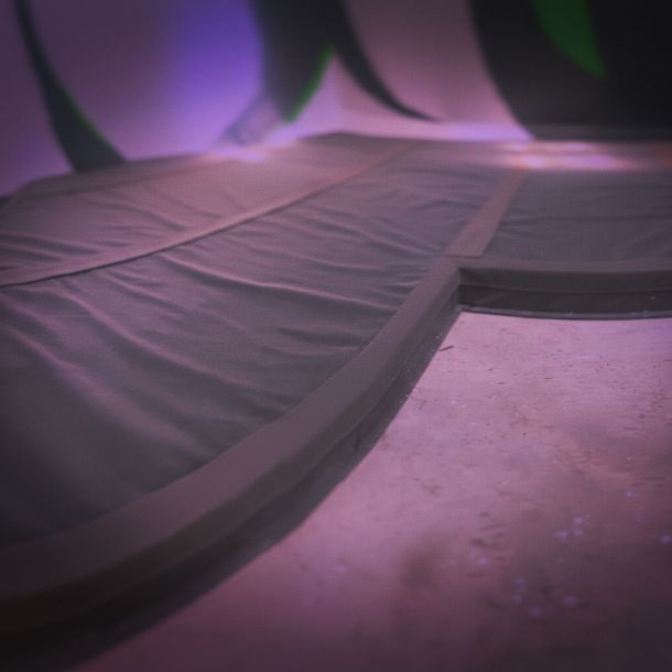 detalle de colchonetas de protección colocadas en el suelo de un rocódromo con iluminación violeta